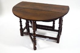 A late 17th Century oak oval gate leg table on turned legs linked by stretchers, 67.