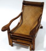 A Colonial planter's teak reclining chair, with cane seat, slide out leg rest,