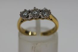 A three stone diamond, 18ct gold ring, the brilliant cuts totalling approximately 0.