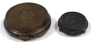 A Chinese bronze vase stand, 26cm diameter, and a Chinese carved hardwood stand, 16.
