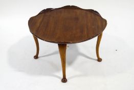 A round mahogany coffee table, with carved lily pad shaped top, on cabriole legs, 75.