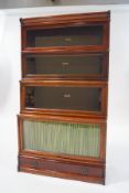 A four tier mahogany Globe Wernick bookcase with a drawer to the plinth and makers label to the