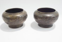 A pair of small footed Japanese bronze vases of squat form,