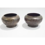 A pair of small footed Japanese bronze vases of squat form,