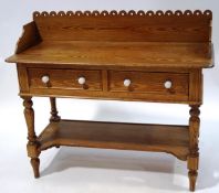 A Victorian pine wash stand with raised pierced back above two drawers and ceramic handles above