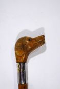 A walking stick with a carved wooden dogs head