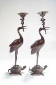 A pair of 20th century Japanese candlesticks, modelled as cranes, standing upon tortoises,