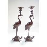 A pair of 20th century Japanese candlesticks, modelled as cranes, standing upon tortoises,