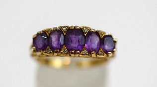 A 9ct gold five stone amethyst ring, the graduated oval cuts with single cut diamond points between,
