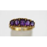 A 9ct gold five stone amethyst ring, the graduated oval cuts with single cut diamond points between,