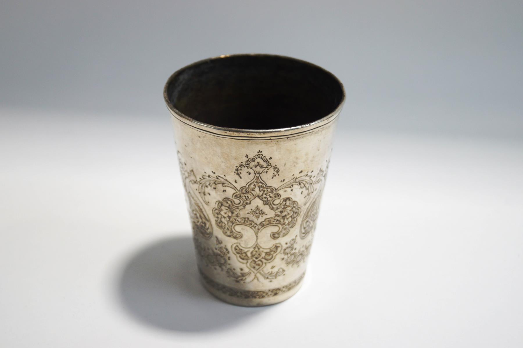 An Iranian silver beaker, stamped marks to the base engraved with foliage flanked by exotic birds,