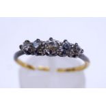 A five stone diamond ring, unmarked, the graduated old brilliant cuts totalling approximately 0.