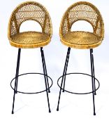 A pair of 1950's/60's bar stools with wicker backs on metal legs linked by a round stretcher