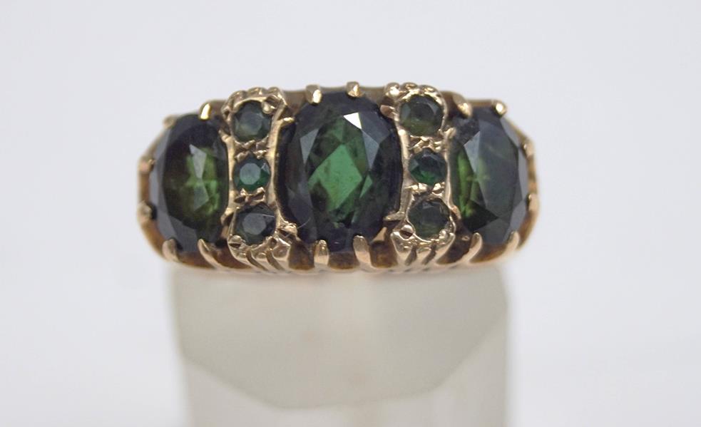 A 9 carat gold green tourmaline ring, the three graduated oval cuts with trios in between,