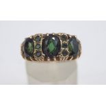 A 9 carat gold green tourmaline ring, the three graduated oval cuts with trios in between,