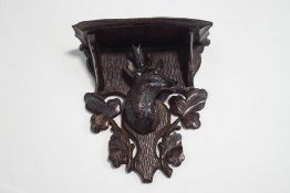 A small Black Forest wall bracket, carved as a deer's head among foliage,