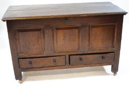 An 18th century oak mule chest with triple panelled front above two drawers with later handles on