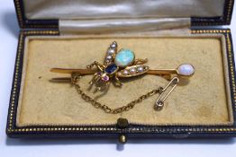 An Edwardian gem set bug bar brooch, the opal abdomen to a sapphire thorax, with ruby set eyes,