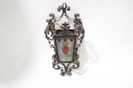 A Victorian ornate wrought iron hanging lantern, with stained glass panels,