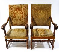 A pair of Victorian armchairs in the 17th century style, with carved lion's head arms,