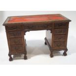 A late Victorian carved oak and mahogany kneehole desk,