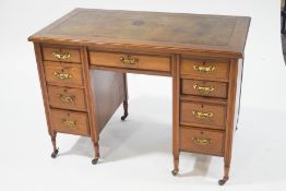 An Edwardian mahogany kneehole desk with leather inset top,