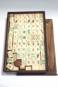 An early 20th century Mah-jong set with bone and bamboo counters, dice, instructions booklet, etc.
