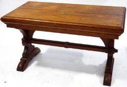 A pitch pine rectangular Gothic style table with deep moulded frieze above two legs,
