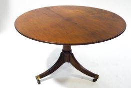 A Regency mahogany breakfast table on outswept legs with brass mounts,