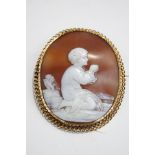 A Victorian shell cameo brooch, unmarked, carved as a child at prayer, with a chain link border, 5.