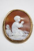 A Victorian shell cameo brooch, unmarked, carved as a child at prayer, with a chain link border, 5.