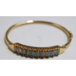 An opal and diamond hinged bangle, stamped '9kt',