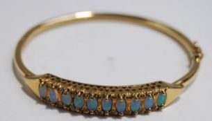 An opal and diamond hinged bangle, stamped '9kt',