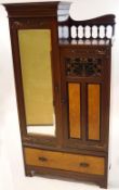 An Art nouveau style wardrobe with copper strap work hinges and walnut panels,