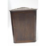 A Georgian style oak hanging corner cupboard,