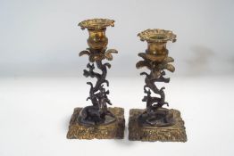 A pair of decorative brass candlesticks, modelled with recumbent deer,