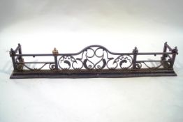 A cast and wrought iron fender with arched centre section,