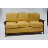 A 20th century beech framed three seater bergere sofa, with patterned upholstery,