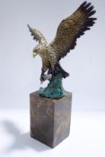 A modern bronze of a flying eagle holding a fish, signed Burnett, with foundry mark,