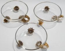 A set of three Victorian footed glass dishes, with gilded scroll handles and feet,