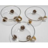 A set of three Victorian footed glass dishes, with gilded scroll handles and feet,