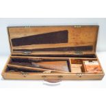 An early 20th century mahogany gun case with key and cleaning materials inside,