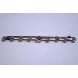 A nine stone diamond bar brooch, the eight old brilliant cuts totalling approximately 1.