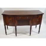 A 19th Century mahogany bow fronted sideboard, the central drawer above a tambour cupboard,