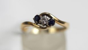 A 9 carat gold three stone sapphire and diamond cross over ring,