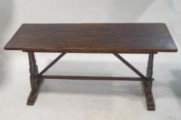 A mahogany rectangular refectory style table with pierced end supports linked by a stretcher, 76.