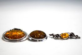 An amber brooch pendant; with two amber brooches;