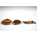 An amber brooch pendant; with two amber brooches;