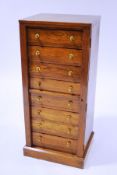 An Edwardian oak Wellington chest with eight drawers, each with gilt metal handles on a plinth base,