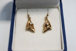 A pair of diamond drop earrings, unmarked, the triangular abstract mount set with a brilliant cut,